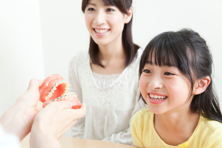 矯正治療をはじめるために母親と歯科医院を訪れた女の子