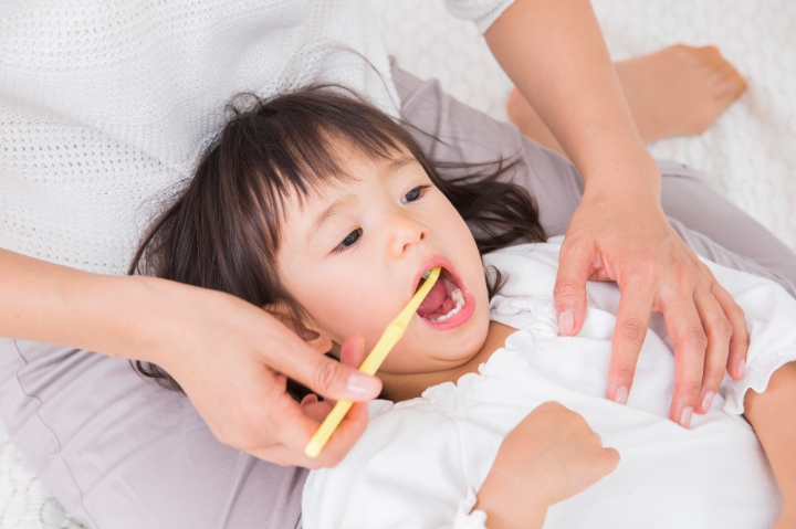 子どもの虫歯を予防するため仕上げ磨きをする親子