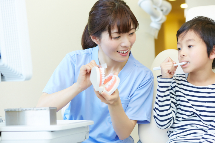 子どもの虫歯を治療するためブラッシング指導をする歯科衛生士